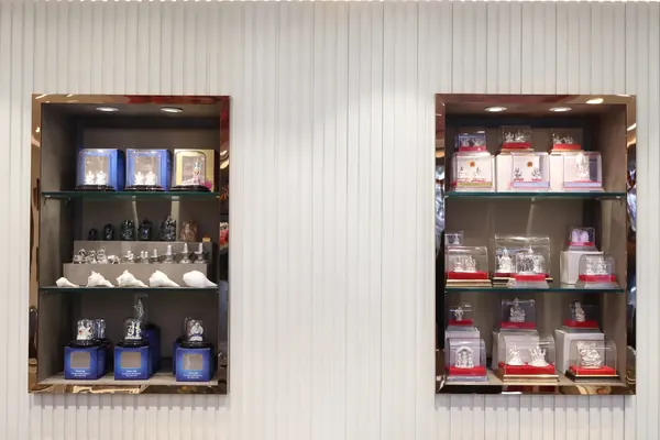 Silver idols, shankh shells and gemstone figurines on glass shelves in the showroom
