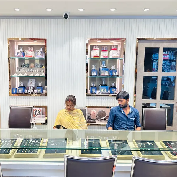 Glass display counter with gold chains and silver idol niches